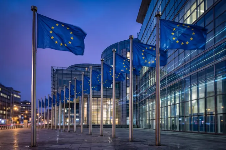 Bandeiras da União Europeia diante de um edifício de vidro em Bruxelas