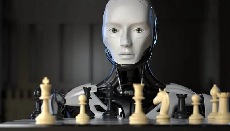 Robô humanoide de rosto branco diante de um tabuleiro de xadrez, com peças claras e escuras em primeiro plano