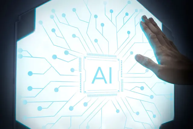 Mão apoiada sobre um painel luminoso hexagonal com um chip central marcado AI e traços de circuito azul.