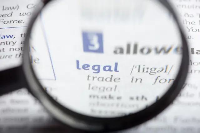Lupa que amplia a palavra «legal» em um verbete de dicionário, com letras azuis e cinzas desfocadas ao redor.