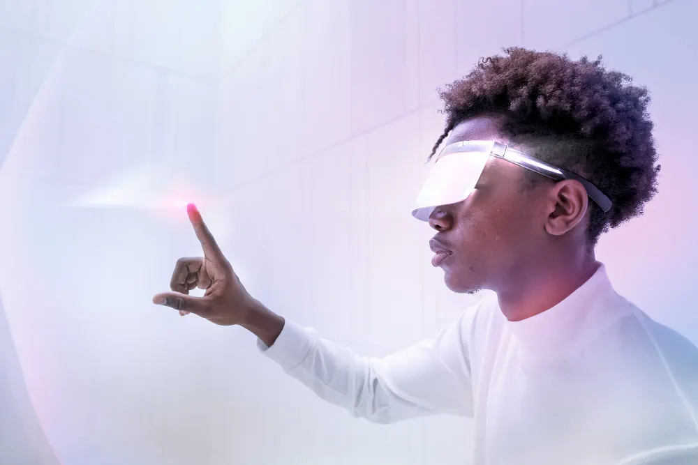 Jovem com viseira transparente aponta o dedo para um ponto de luz rosa sobre um fundo branco e violeta.