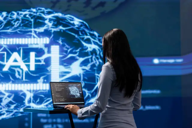 Mulher diante de uma tela com um cérebro digital e as letras AI, com um notebook sobre um suporte