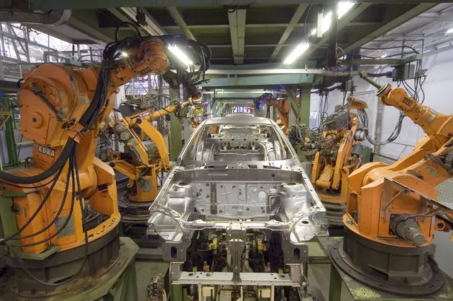 Robôs industriais KUKA trabalhando em uma linha de fabricação automotiva